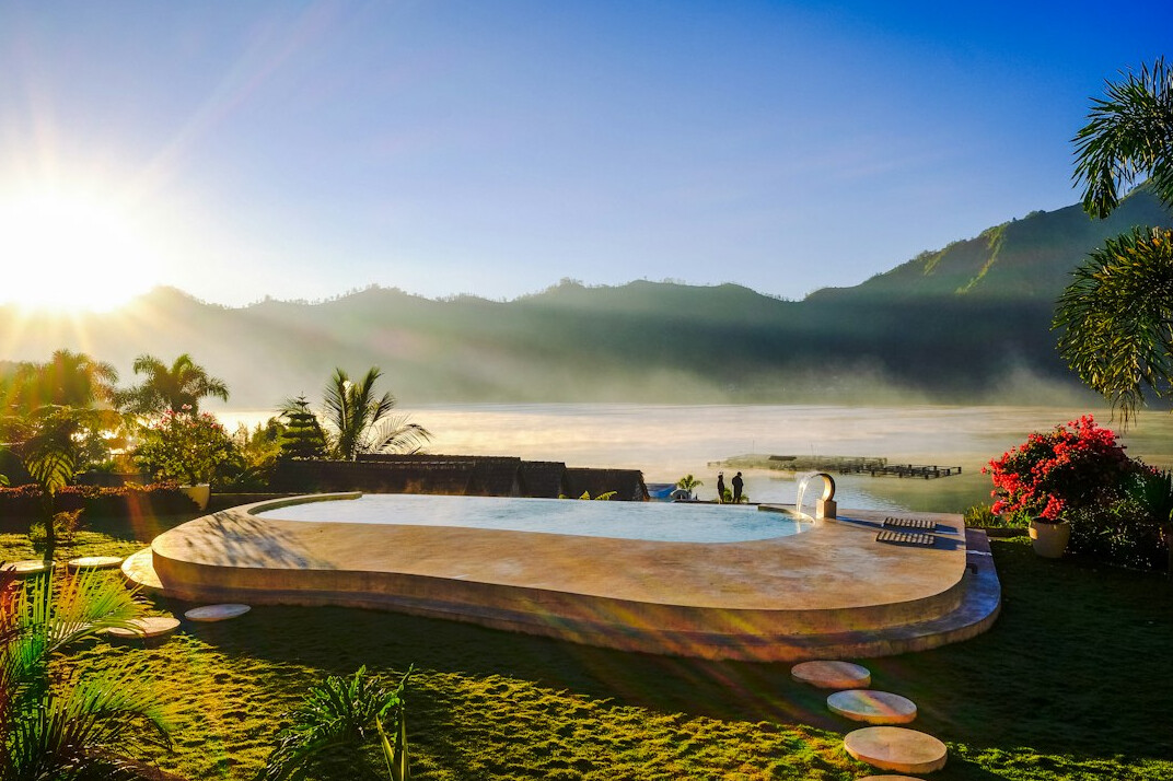 Villa garden terrace with pool and mountain view at sunset